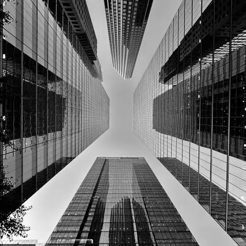 Black-and-white upward view between office skyscrapers