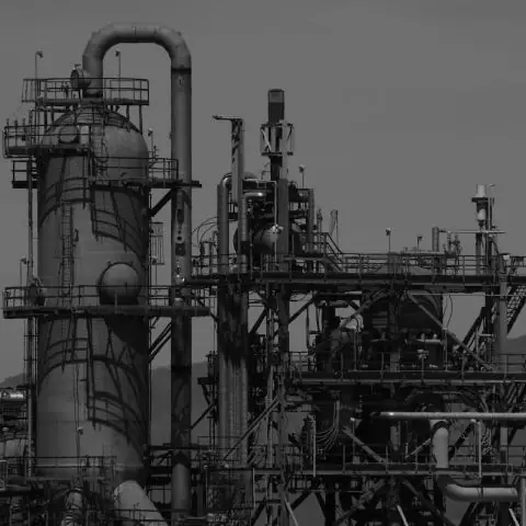 Black-and-white view of refinery towers and pipework